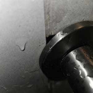 צינור מתכת עם סימני נזילה על קיר