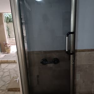 דלת זכוכית עם ידית מתכת במסגרת מתכתית