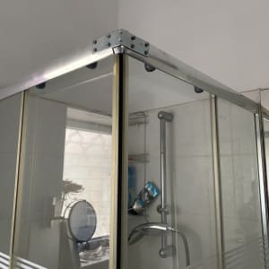 מקלחון זכוכית עם ברז ומדף במקלחת