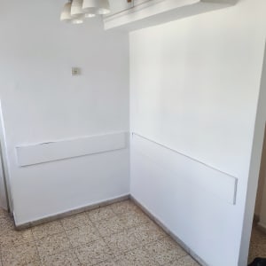 קיר צבוע בלבן עם רצפת אריחים