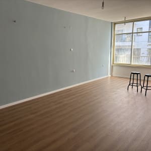 רצפת פרקט עץ בחדר ריק עם שני כיסאות