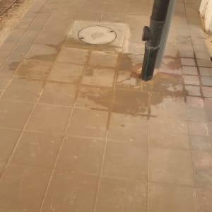 צינור ביוב על רצפה רטובה עם כתמי מים