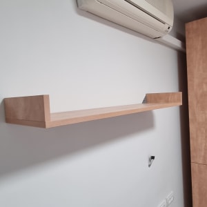 מדף עץ מותקן על קיר לבן