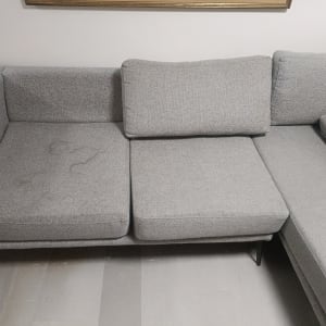 ספה אפורה עם כתמים קלים על המושב