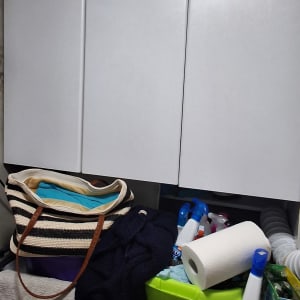 מוצרי ניקוי ומגבות על מדף במטבח