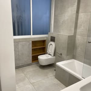 חדר אמבטיה עם חלון מלוכלך, אסלה ואמבטיה