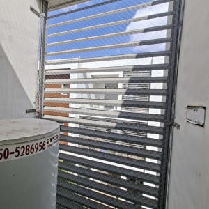 רשת מתכת על חלון עם נוף חיצוני