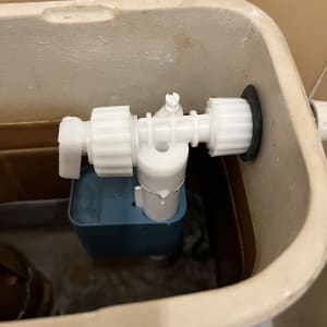 שסתום פלסטיק לבן בתוך מיכל הדחה של אסלה