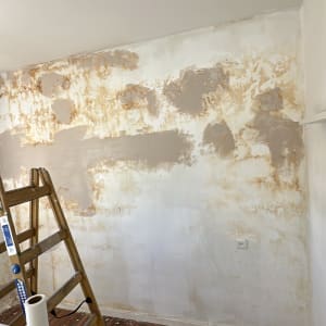 קיר בתהליך שיפוץ עם סולם וכלי עבודה