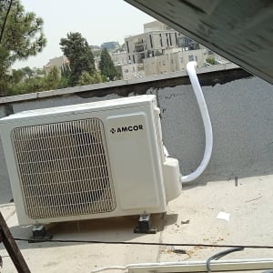 יחידת מיזוג אוויר על גג עם צינור לבן