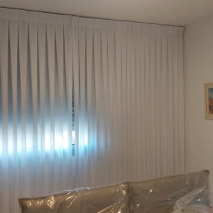 וילון אנכי לבן מותקן על חלון