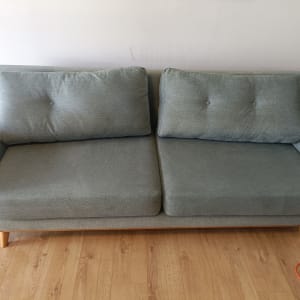 ספה אפורה על רצפת עץ עם כבל כתום בצד