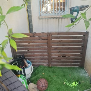 חצר קטנה עם דשא סינתטי וכלי עבודה