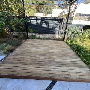 דק עץ בגינה עם צמחייה מסביב