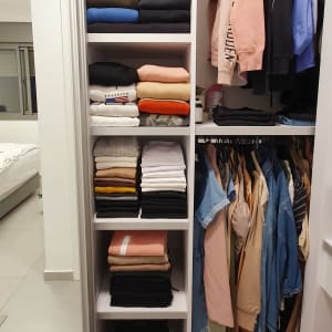 ארון בגדים מסודר עם בגדים מקופלים ותלויים