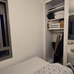 חדר שינה עם ארון פתוח ומיטה מסודרת