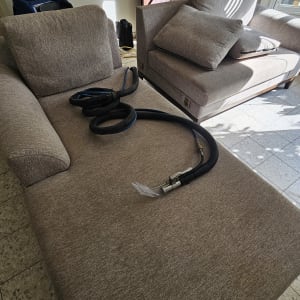 ספה עם ציוד ניקוי מקצועי בחדר מואר