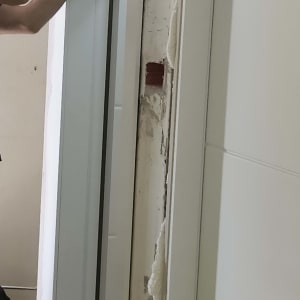 אדם מתקין דלת עם מברגה חשמלית