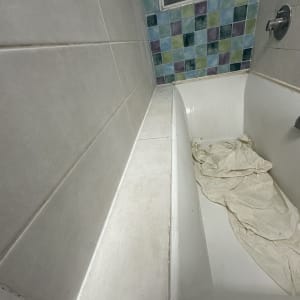 חדר אמבטיה עם אריחים צבעוניים ואמבטיה לבנה