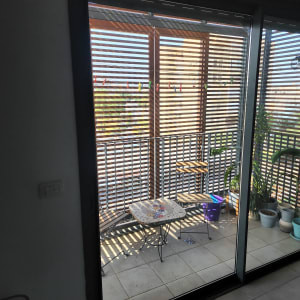 מרפסת עם דלת זכוכית, שולחן וכיסאות