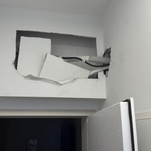 חור בקיר עם צינורות חשופים