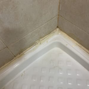 פינת מקלחת עם קירות אריחים ואיטום ישן