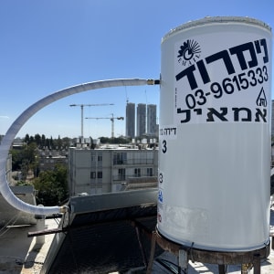 דוד שמש על גג עם צינור ומיכל לבן