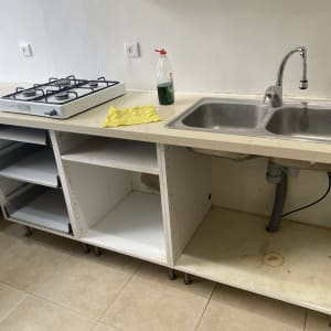 בקבוק חומר ניקוי ומטלית ליד כיור מטבח