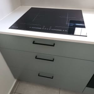 התקנת כיריים אינדוקציה שחורות על משטח עבודה במטבח