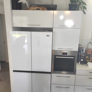 ארונות מטבח לבנים בגימור מבריק עם נישה מותאמת לתנור אפייה מובנה