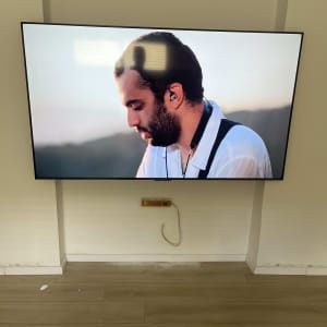 טלוויזיה מותקנת על קיר עם חוטים גלויים