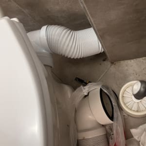 צינור גמיש לבן מחובר לאסלה בחדר אמבטיה