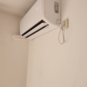 מזגן מותקן על קיר עם שקע חשמל