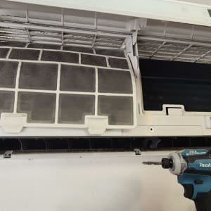 מזגן פתוח עם מסננים מלוכלכים ומברגה חשמלית