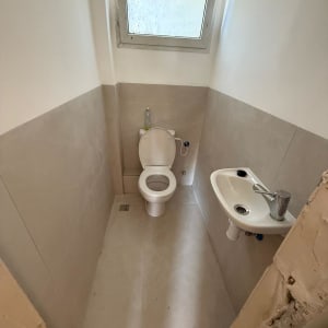 שירותים עם כיור קטן וחלון עליון