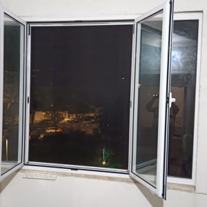 חלון אלומיניום לבן עם פתיחת ציר כפולה ורשת יתושים