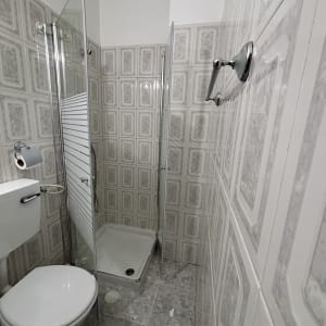 מקלחת עם דלת זכוכית ושירותים בחדר אמבטיה