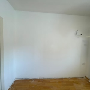 קיר גבס לבן עם חוטים חשמליים חשופים