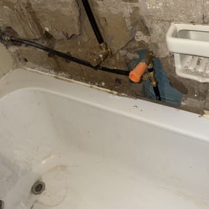 צנרת חשופה בקיר מעל אמבטיה