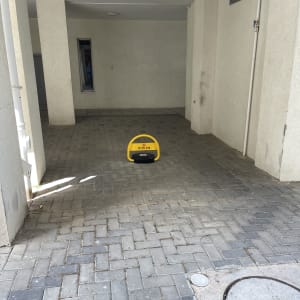 מחסום חניה צהוב על רצפת אבנים משתלבות