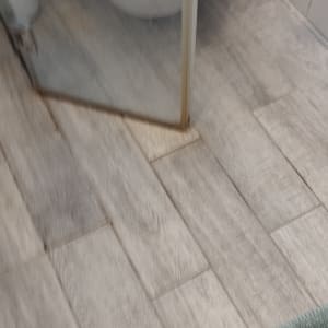 מקלחון עם רצפת עץ ומגבת ירוקה