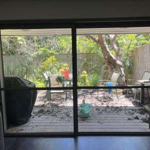 דלי ירוק ומטאטא על רצפת עץ בחצר