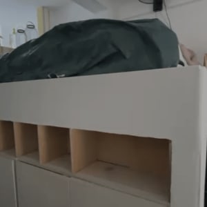 מיטה מוגבהת עם מדפים בחדר שינה