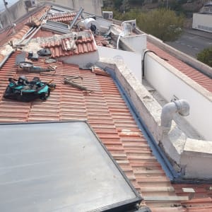 עבודות תיקון על גג רעפים עם כלים וציוד
