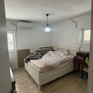 חדר שינה עם מיטה, מנורה ותמונות על הקיר