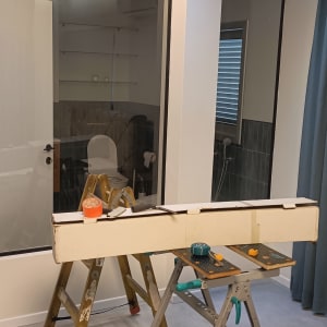 סולם, שולחן עבודה, קרטון וכלי עבודה בחדר