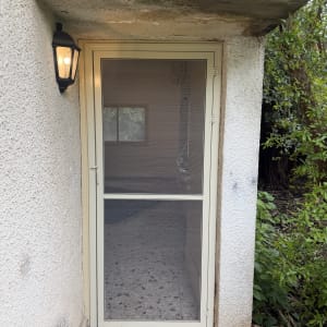 דלת אלומיניום עם רשת ליד קיר חיצוני