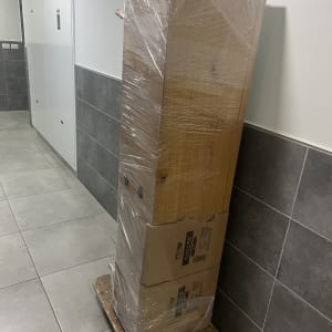 ארון עטוף בניילון על עגלת הובלה במסדרון