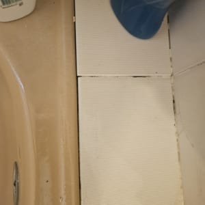 אריחים ליד כיור עם בקבוק חומר ניקוי