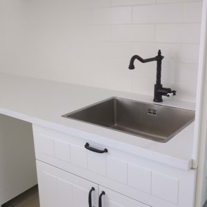 כיור נירוסטה עם ברז שחור במטבח לבן